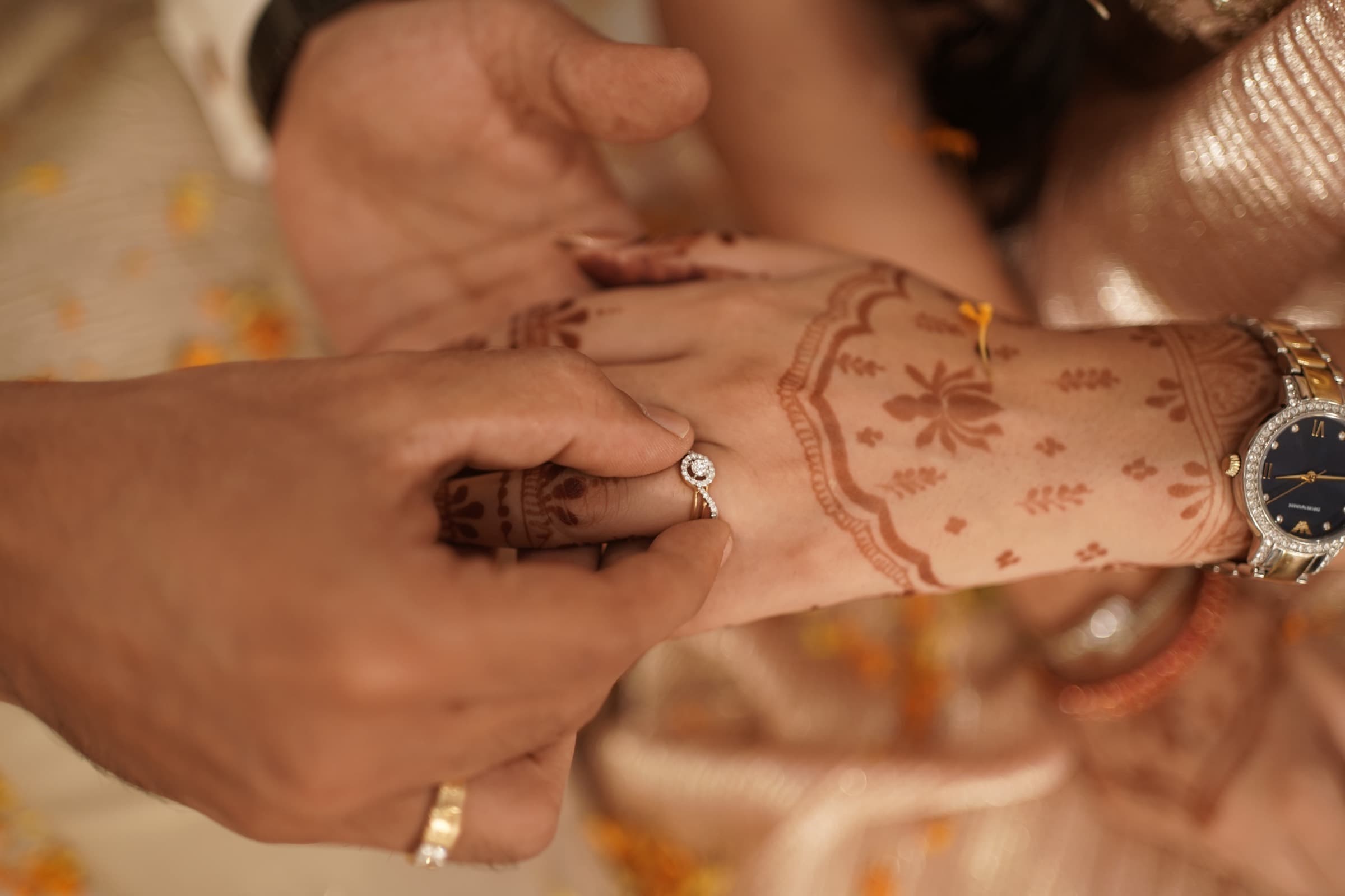 Mayank placing a ring on Nancy's mehndi-covered hand